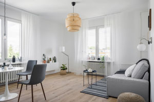 Vardagsrum med soffa, litet bord och vita gardiner