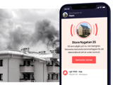 Rök från ett tak på ett flerfamiljshus samt en mobil med app som larmar om brand i lägenhet nära dig.