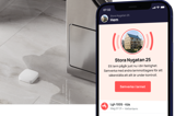 Vattensensor på köksgolv samt en mobil med app som larmar om vattenläckage.